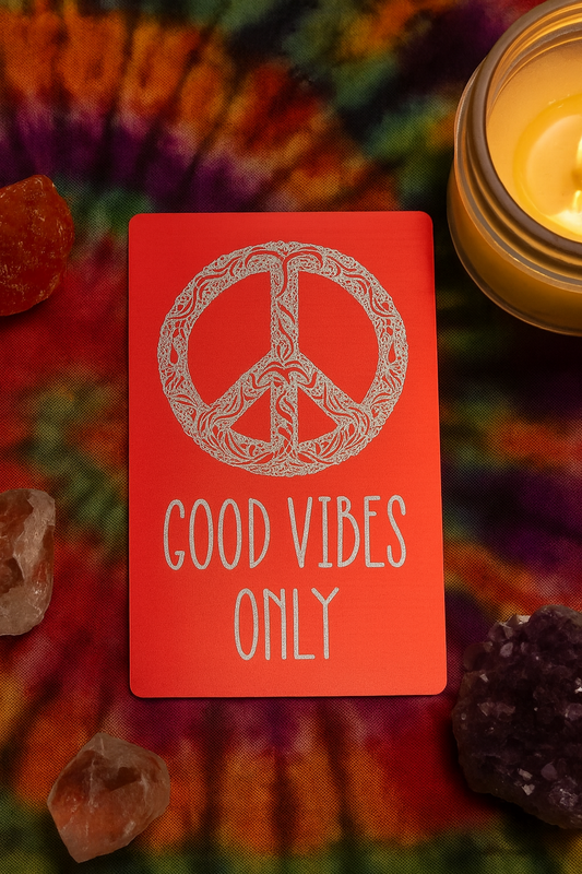 Red/silver metal laser engraved keepsake card with peace symbol and 'Good Vibes Only' text on a tie-dye background with a candle and crystals.
