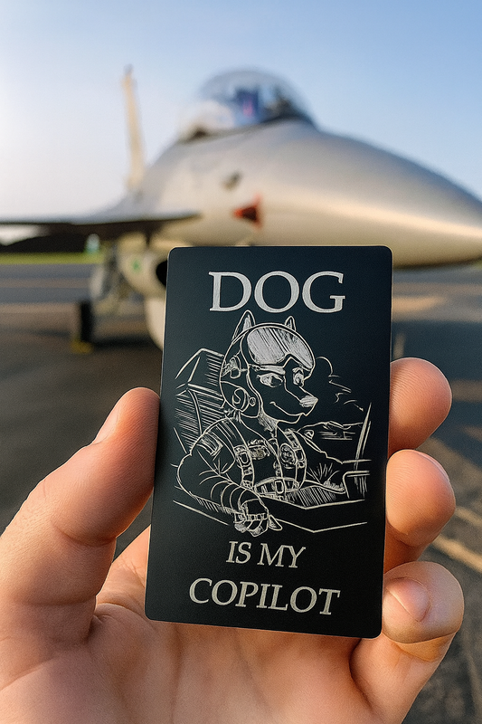Hand holding a card with 'DOG IS MY COPILOT' text in front of an airplane.