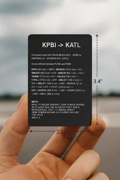 Hand holding a small black card with flight plan engraving set against a blurred airport background.