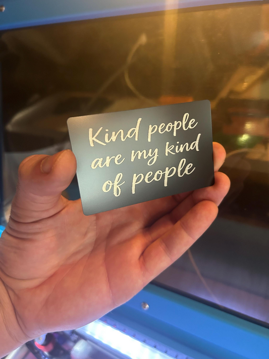 Hand holding a laser engraved thoughtful sweet greeting metal card with 'Kind people are my kind of people' text.