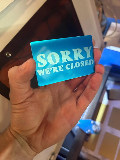 blue metal signage with 'Sorry We're Closed' text