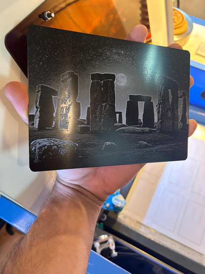 Metal plaque sized 7x5" with Stonehenge design held by a person against a blurred background
