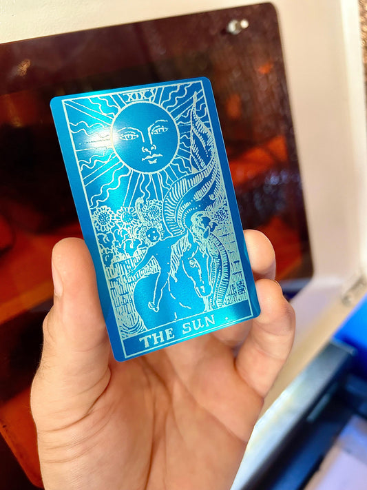 Metal laser engraved "The Sun" tarot card in blue/silver anodized aluminum