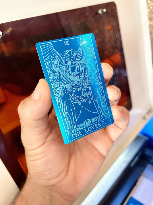 Laser engraved metal tarot card with The Lovers design in blue/silver