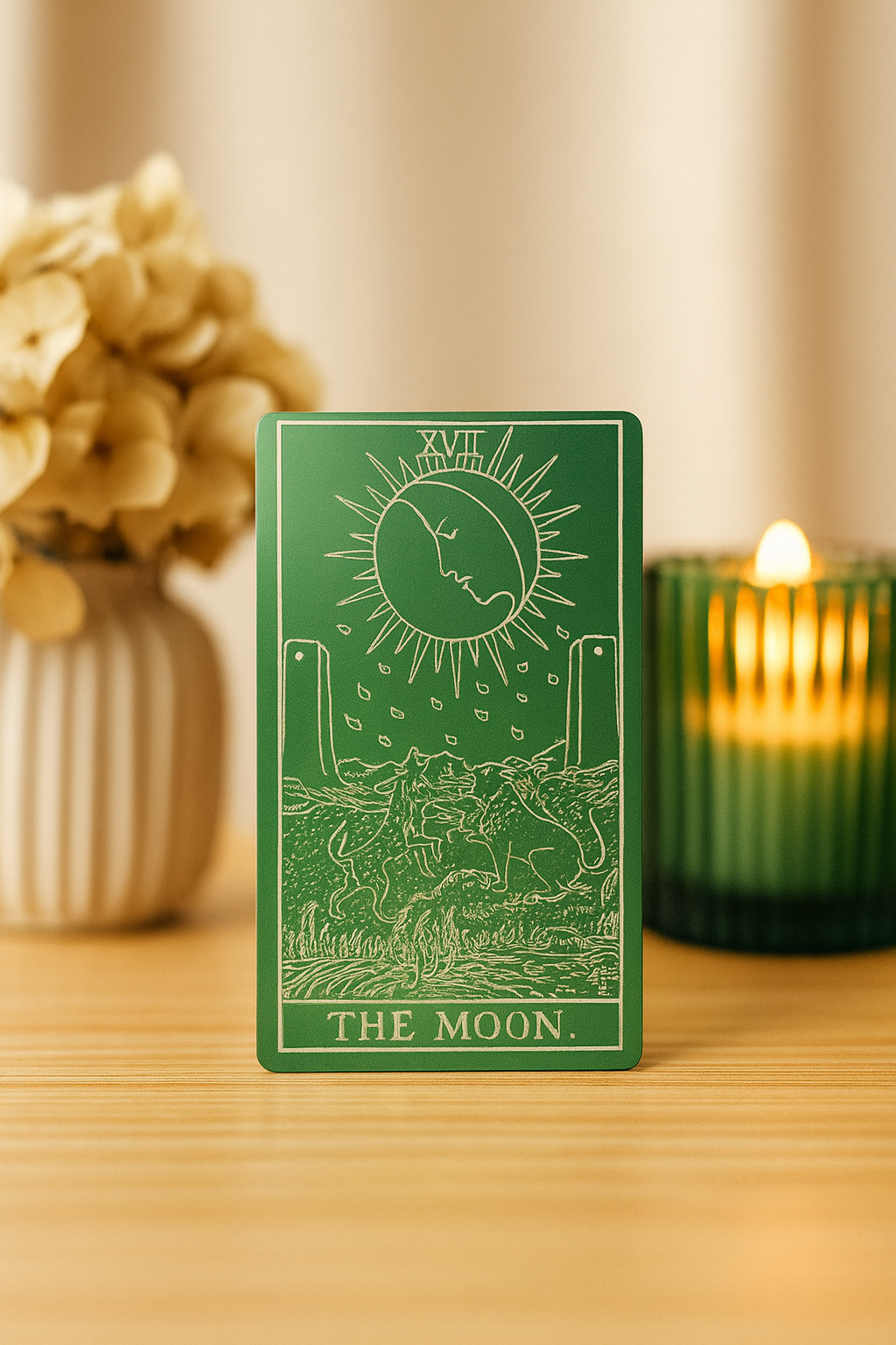 Green/silver metal tarot card engraving  titled 'The Moon' on a wooden surface with decorative elements.