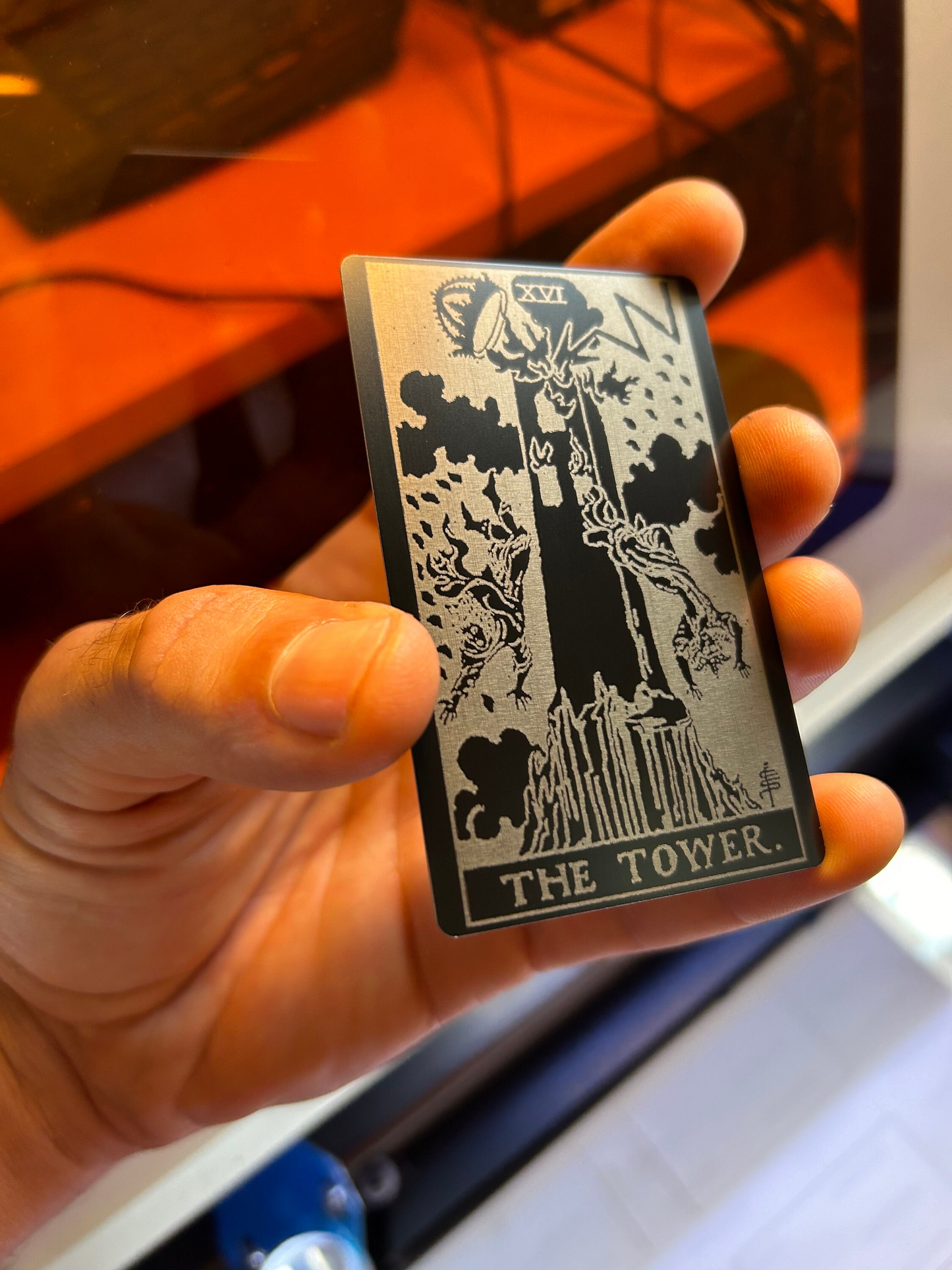 laser engraved metal tarot card with The Tower design in anodized aluminum