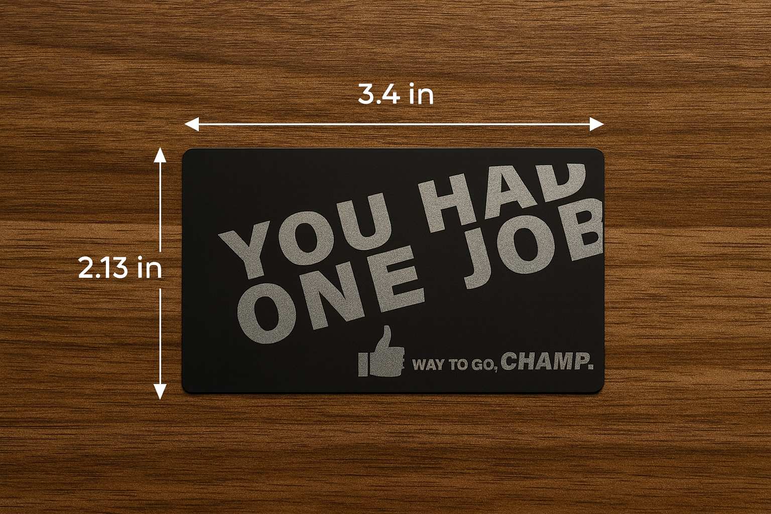 Metal gift card with text 'YOU HAD ONE JOB WAY TO GO, CHAMP.' on a wooden surface with measurements.